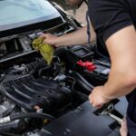 Close-up of mechanic repairing a car engine, focusing on maintenance and cleaning.